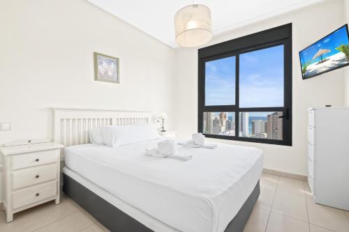 ベニドルムにあるGemelos 26 Resort Apartment 16-A Levante Beachの白いベッドルーム(大型ベッド1台、窓付)