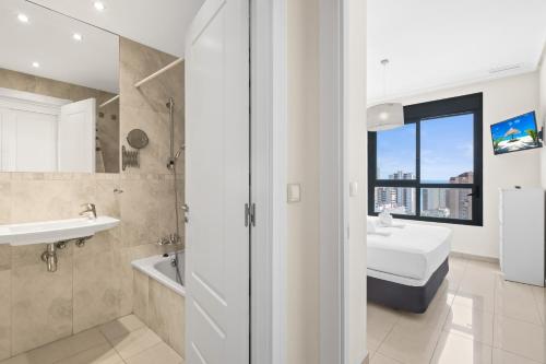 ベニドルムにあるGemelos 26 Resort Apartment 16-A Levante Beachのバスルーム(洗面台、トイレ付)、窓が備わります。