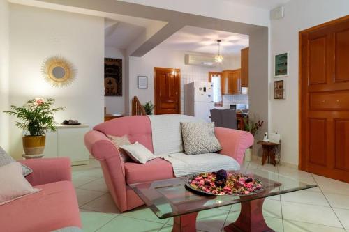 a living room with a pink couch and a table at Norma’s House in Khlóï