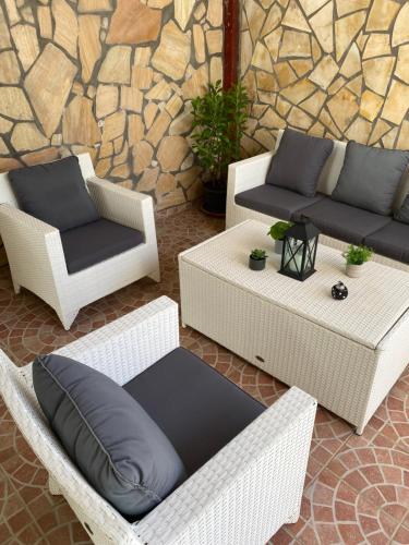 a group of wicker chairs and couches on a patio at Tilys lodge in Capesterre-Belle-Eau