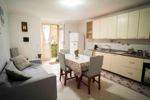 una cucina con tavolo, sedie e un divano di Casa Elena - casa vacanze Napoli centro a Napoli