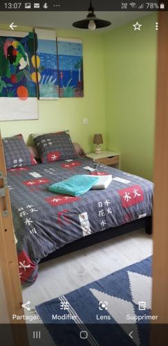 um quarto com uma cama com um edredão azul em Maison proche océan em Saint-Hilaire-de-Riez