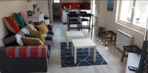 uma sala de estar com um sofá e uma mesa em Maison proche océan em Saint-Hilaire-de-Riez