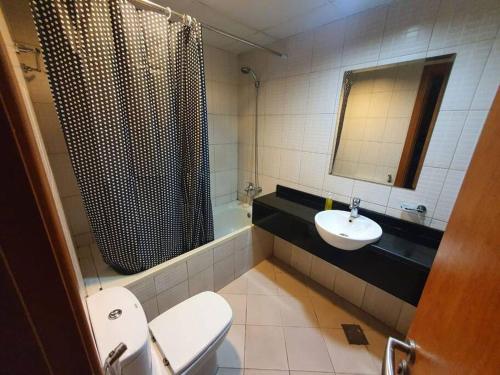a bathroom with a toilet and a sink and a shower at Spacious Studio in IMPZ in Dubai