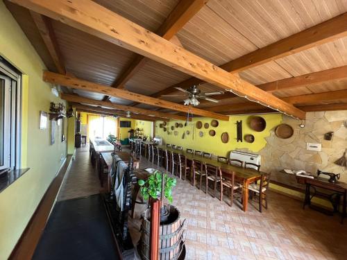 un restaurante con techos de madera, mesas y sillas de madera en Agriturismo la Cantina, en Baratili San Pietro