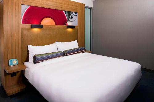 a white bed with two pillows on top of it at Aloft Cleveland Downtown in Cleveland