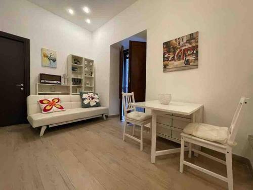 a living room with a desk and a table and chairs at Appartamento nel Borgo in Orte