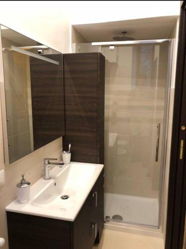a bathroom with a sink and a shower with a mirror at Appartamento nel Borgo in Orte