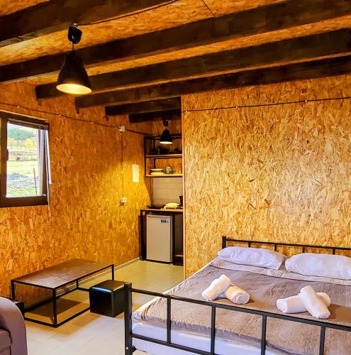 a bedroom with a bed and a wooden wall at Kazbegi 5054 in Kazbegi