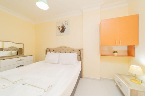 sypialnia z białym łóżkiem i lustrem w obiekcie Flat w mieście Antalya