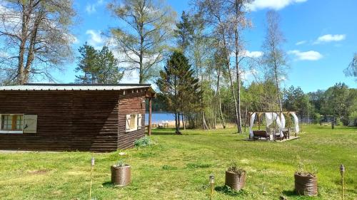 a log cabin in a field with a tent at Ma Cabane Au Bord Du Lac in Neuvic