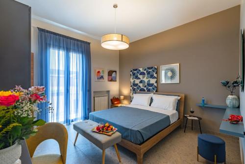 a bedroom with a bed and a table with a bowl of fruit at Macramè Suites in Sciacca