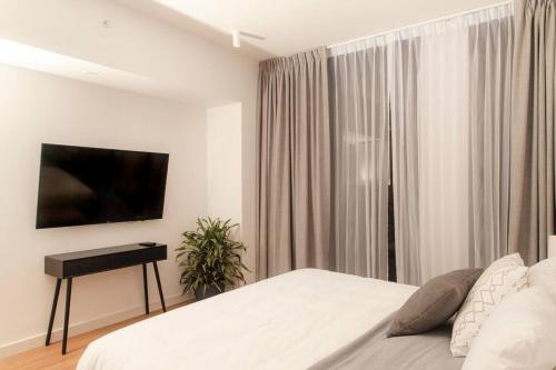 um quarto com uma cama, uma televisão e uma mesa em Apartamento una habitación DLX em Echeverría