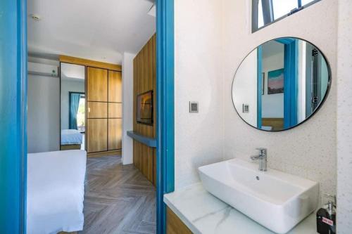 y baño con lavabo y espejo. en Cát Lợi Phú Quốc Hotel en Phu Quoc