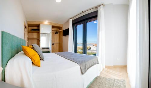 una camera con un letto e una grande finestra di Apartamentos Villa Zoila Nigrán a Nigrán