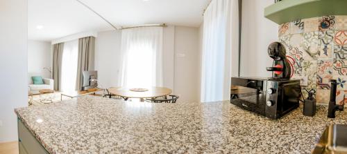 a kitchen with a counter top and a living room at Apartamentos Villa Zoila Nigrán in Nigrán