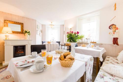 a dining room with white tables and a fireplace at Villa Sonnenseite Jonsdorf in Kurort Jonsdorf