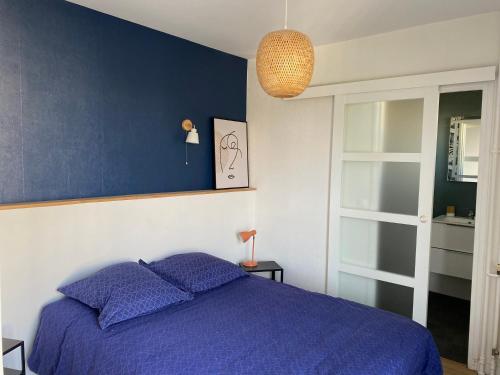 um quarto com uma cama roxa e uma parede azul em Centre Reims Cathédrale avec balcon em Reims