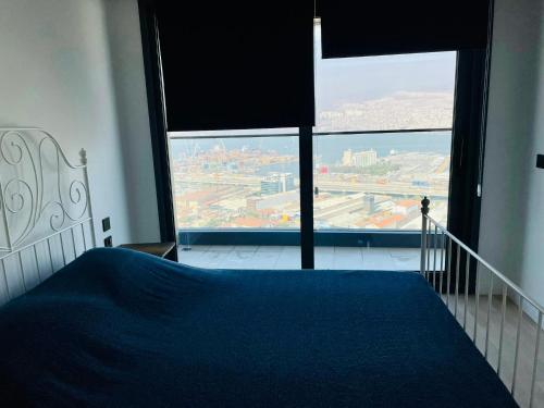a bedroom with a blue bed and a large window at Luxury residence with sea view in Konak