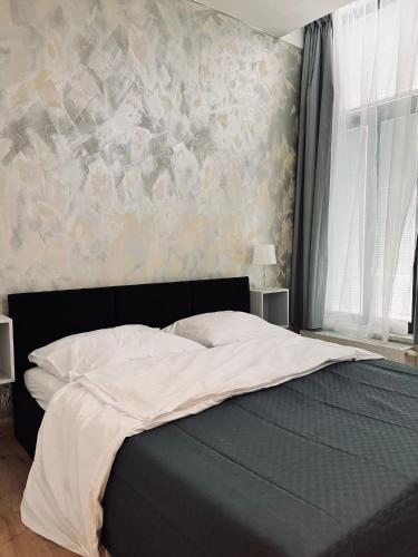 a bedroom with a bed with a painting on the wall at SOFI living in Ostrava