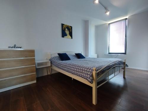 sypialnia z łóżkiem z niebieskimi poduszkami w obiekcie Sleep and Wine w mieście Batumi