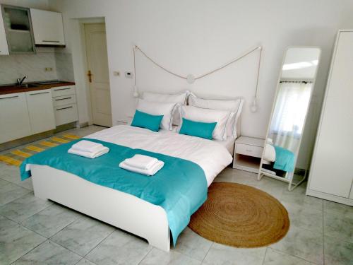 a bedroom with a large bed with two towels on it at Olive Tree Apartments in Umag