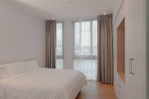 a bedroom with a white bed and a large window at Junior Suite DLX Aeropuerto in Echeverría