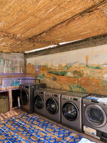two washing machines in a room with a painting on the wall at Kasbari House in Taghazout