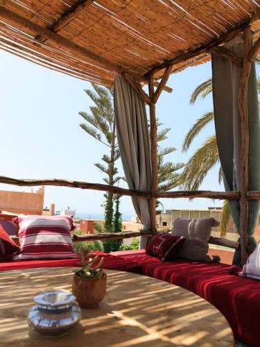 a group of beds sitting under a pergola at Kasbari House in Taghazout