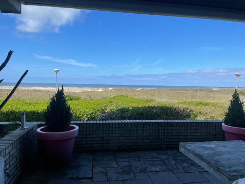 een uitzicht op het strand vanaf de patio van een huis bij Vitamine Zee in IJmuiden