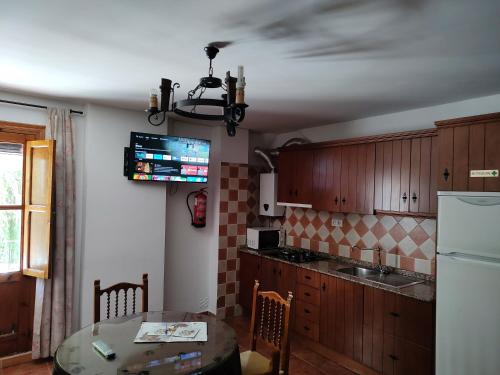 a kitchen with a table and a refrigerator at Alojamiento Rural El Molino De La Cerrada in Castril