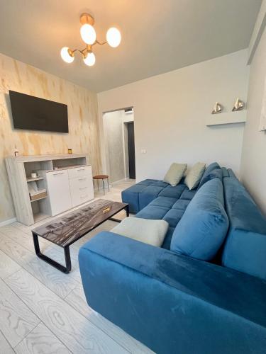 a living room with a blue couch and a tv at Citadella In City in Constanţa
