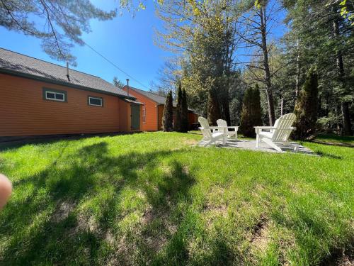 two white chairs sitting in the grass in a yard at The Inn & More in Bartlett