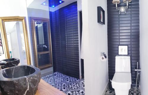 La salle de bains est pourvue d'une douche carrelée de noir et d'une baignoire. dans l'établissement Apartamento MarySol B con Terraza y Piscina privada, à Benalmádena