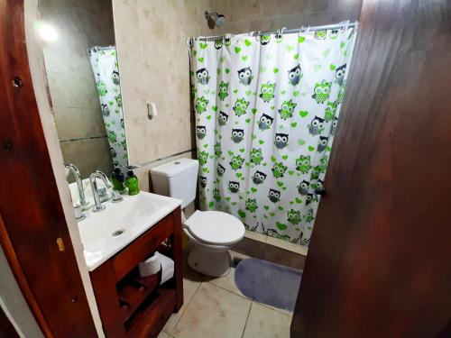 a bathroom with a toilet and a shower curtain at departamento villa gesell in Villa Gesell
