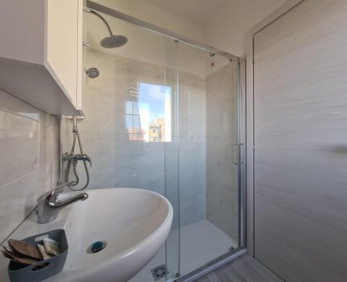 a bathroom with a shower and a white bath tub at Civico 14 Apartment 3 in Monserrato