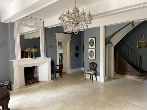 un salon avec un lustre et une cheminée dans l'établissement La Bourdette - Elegantes Herrenhaus im Boutique Stil, à Daumazan-sur-Arize