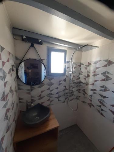 une salle de bain avec une douche avec un lavabo et un miroir dans l'établissement Maison de pêcheurs climatisée bord de mer, à Saint Cyprien Plage