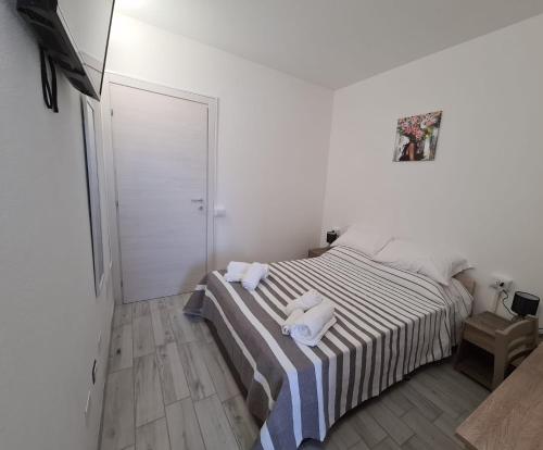 a bedroom with a bed with towels on it at Civico 14 Apartment 3 in Monserrato