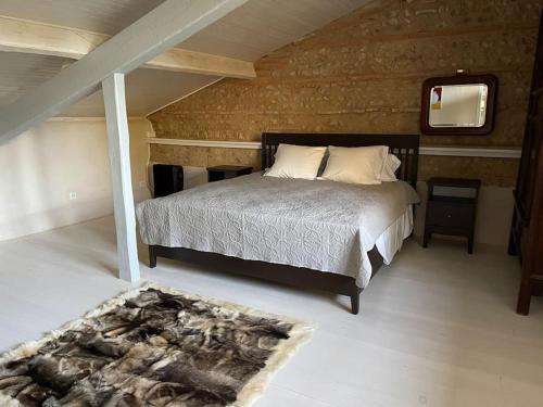 a bedroom with a large bed and a mirror at La Bourdette - Elegantes Herrenhaus im Boutique Stil in Daumazan-sur-Arize