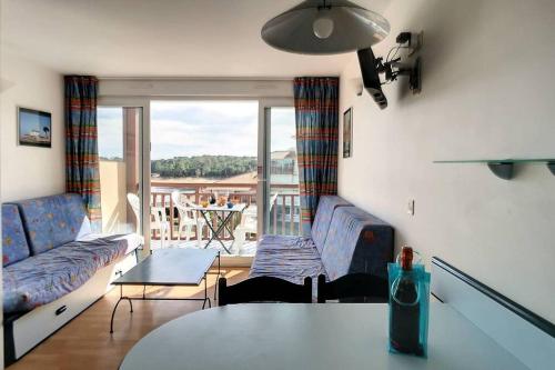 un salon avec un canapé et une table dans l'établissement V-Marin 05-Vieux Boucau appartement 4 personnes avec vue sur lac marin dans résidence avec piscine, à Vieux-Boucau-les-Bains