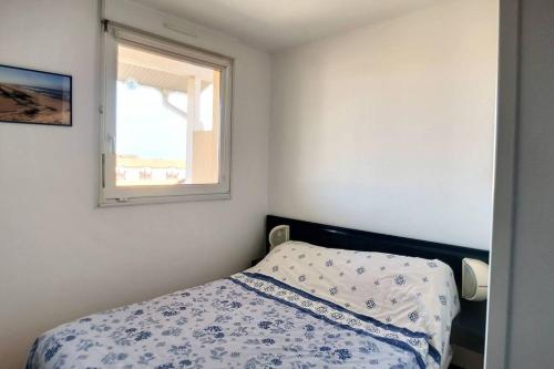 une petite chambre avec un lit et une fenêtre dans l'établissement V-Marin 05-Vieux Boucau appartement 4 personnes avec vue sur lac marin dans résidence avec piscine, à Vieux-Boucau-les-Bains