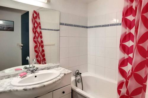 La salle de bains est pourvue d'un lavabo et d'une baignoire. dans l'établissement V-Marin 05-Vieux Boucau appartement 4 personnes avec vue sur lac marin dans résidence avec piscine, à Vieux-Boucau-les-Bains