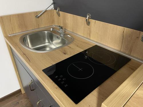 eine Küche mit einem Waschbecken in einem Holzschrank in der Unterkunft Damade apartments in Jajce