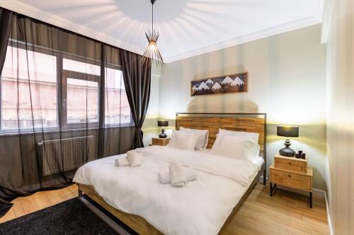 ein Schlafzimmer mit einem großen Bett mit weißer Bettwäsche und Kissen in der Unterkunft Modern and Well Designed Apartment Near Public Transportation in Maltepe in Istanbul