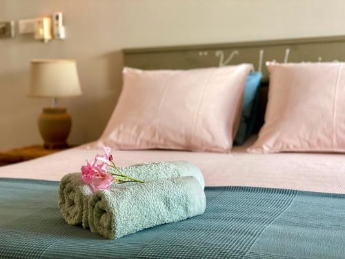 ein Bett mit einem Handtuch mit einer Blume darauf in der Unterkunft Tala Lodge Bonaire in Kralendijk