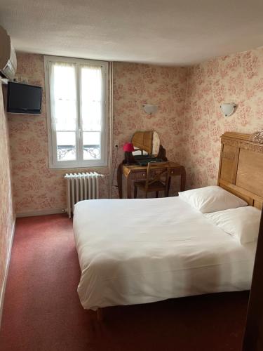 sypialnia z łóżkiem, biurkiem i oknem w obiekcie Le Coq d'Or w mieście Brive-la-Gaillarde