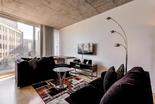 een woonkamer met een bank en een tv bij Les Immeubles Charlevoix - Le 760309 in Québec