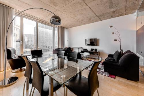 Les Immeubles Charlevoix - Le 760309 في مدينة كيبك: غرفة طعام مع طاولة زجاجية وكراسي سوداء