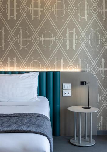 a bedroom with a bed and a table at DIVA HOTEL LIGNANO - Adults Only in Lignano Sabbiadoro